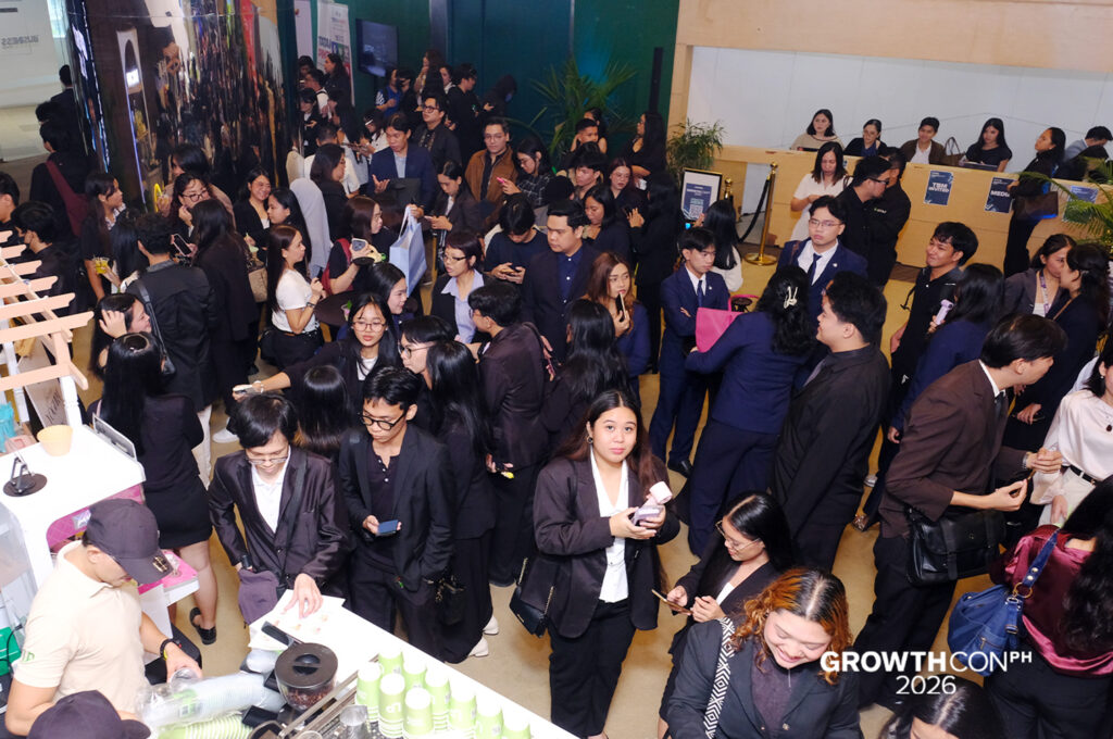 Crowd of professionals in business attire at a busy conference or expo, with booths along the hall and a GrowthCONPH 2026 watermark in the corner.